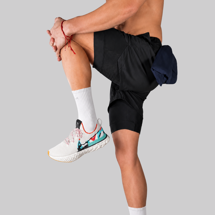TROS Resilience PDP 2026-05 · Short Resilience - Negro Calza Negra · 07 · 07 model side/back dynamic with toallero visible